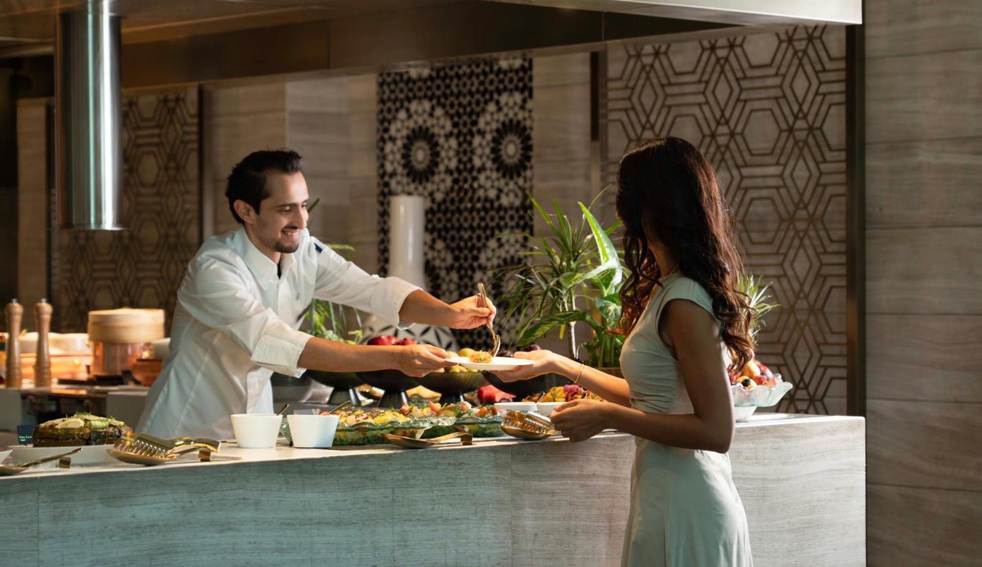 Fairmont Riyadh Ngoại thất bức ảnh A chef serving a guest at the buffet